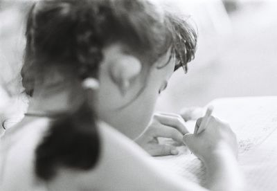 Close-up of girl writing on book at home