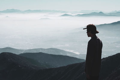 Man standing on mountain against sky