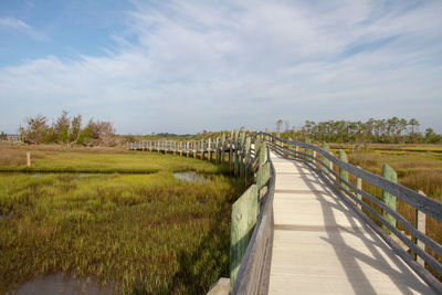 Scenic view of coastal marsh against sky with boardwalk hiking trail 