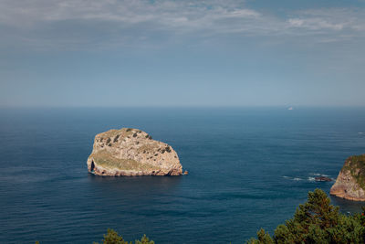 View of rocks in sea against sky
