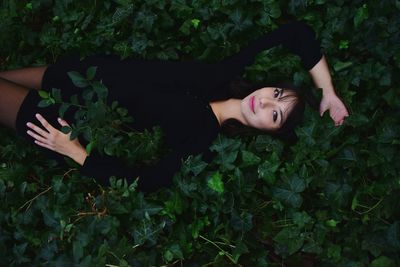 High angle portrait of fashion model lying on plants
