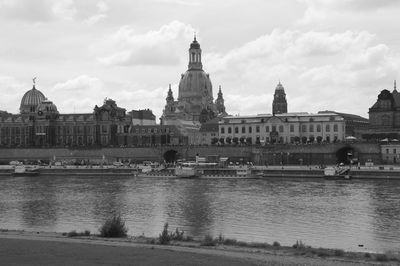 River by buildings and dresden frauenkirche against cloudy sky