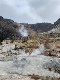 Scenic view of waterfall on mountain against sky