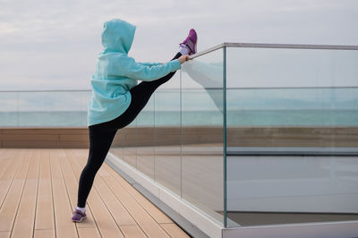 Full length of young woman exercising at home