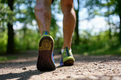 Low section of man tying shoelace