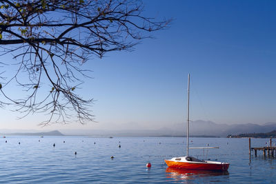 Sailboats in lake against clear sky