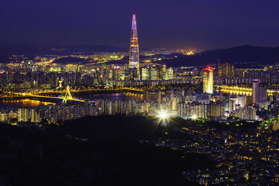 Illuminated buildings against sky at night