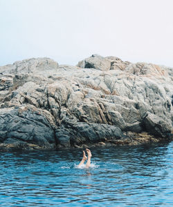 Man swimming in sea against clear sky