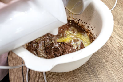 Mixing the dough with a hand mixer with a whisk with melted butter added, the dough is thick mass.