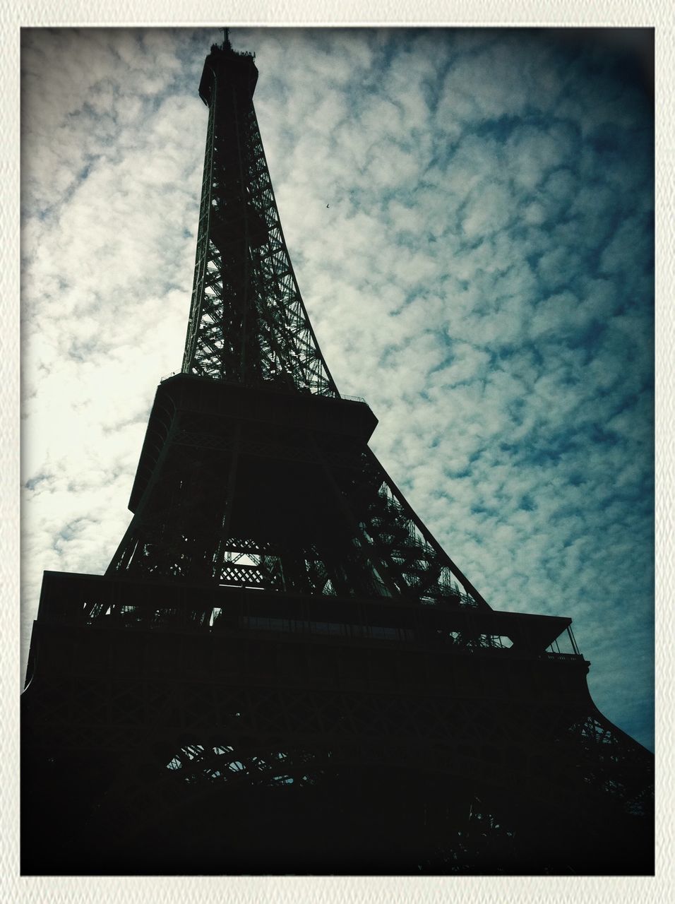 architecture, built structure, low angle view, sky, building exterior, cloud - sky, transfer print, tower, tall - high, auto post production filter, cloudy, eiffel tower, international landmark, famous place, travel destinations, cloud, city, metal, capital cities, outdoors