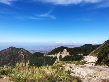 Scenic view of mountains against blue sky