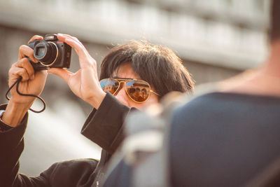 Close-up of woman photographing with mobile phone