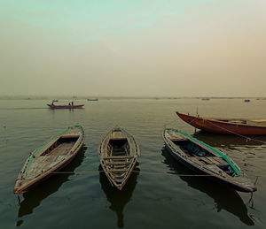 Boats moored in sea against sky