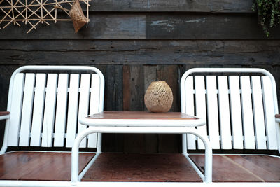 Empty chairs and table against wall