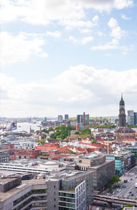 High angle view of city buildings against cloudy sky