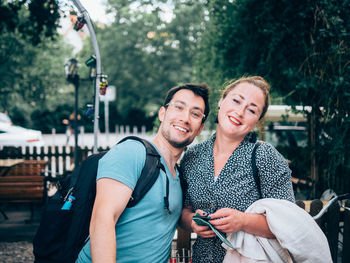 Happy young woman using mobile phone in park