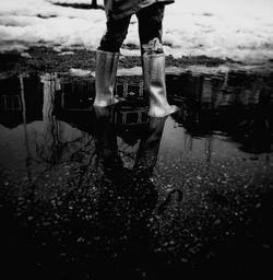 Low section of man standing in puddle