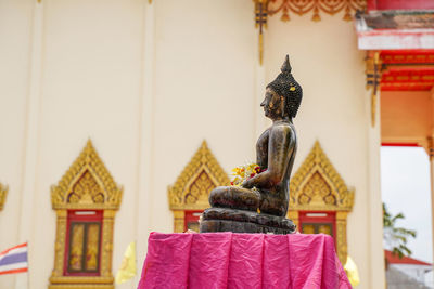 Statue outside temple against building