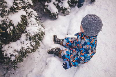 High angle view of boy standing on snow covered field