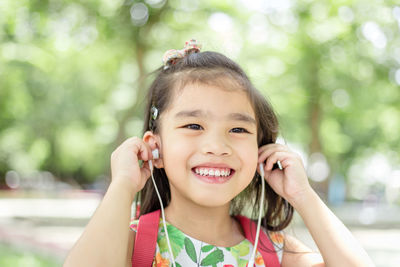 Close-up portrait of happy girl with mobile phone