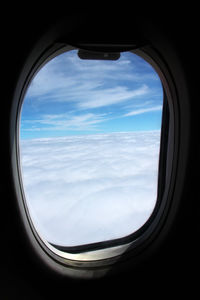 View of cloudy sky seen through airplane window