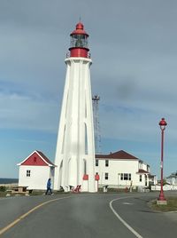 Lighthouse by sea against sky