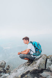 Man with arms outstretched against mountain