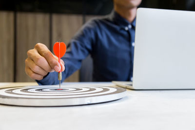 Midsection of man using laptop on table