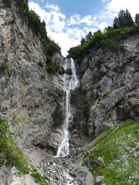 Low angle view of waterfall against sky