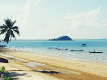 View of calm beach against cloudy sky