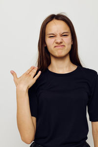 Portrait of teenager gesturing against white background