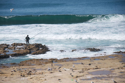 High angle view of person fishing at sea shore