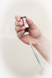 Close-up of woman holding hands over white background