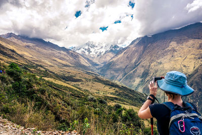 Rear view of people on mountain against sky