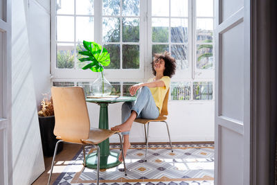 Portrait of smiling woman sitting on chair at home