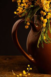 Close-up of yellow flower pot on table