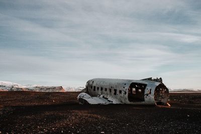 Abandoned airplane against sky during sunset