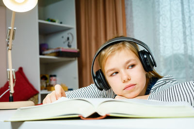 Portrait of boy on book at home