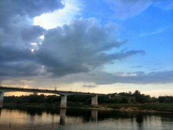 Bridge over river against cloudy sky