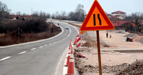 Close-up of road sign against sky