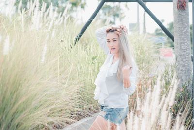 Portrait of woman standing amidst grass