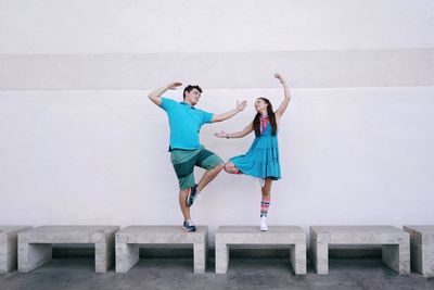 Couple dancing on seats against wall