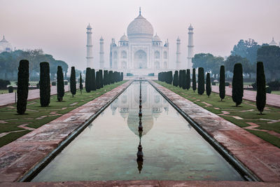Reflection of taj mahal on reflecting pool during sunset