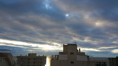 Low angle view of buildings against cloudy sky