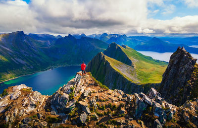 Rear view of man walking on mountain against sky