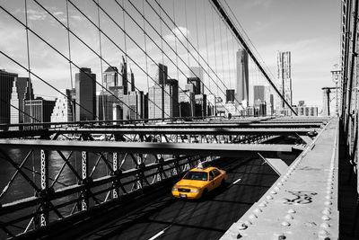 Taxi on brooklyn bridge against manhattan skyline