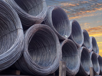 Close-up of stack of pipes against sky at sunset