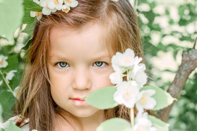 Close-up portrait of girl with pink flower