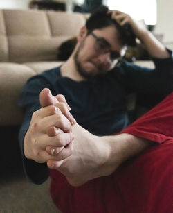 Midsection of man sitting on sofa