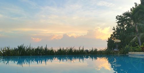 Swimming pool against sky during sunset